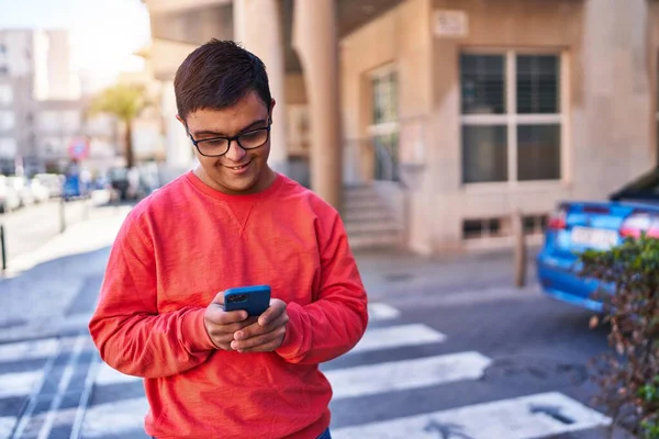唐氏综合症男人在街上用智能手机充满自信地微笑 — 图库照片
