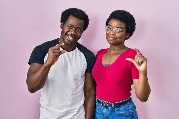 Young African American Couple Standing Pink Background Smiling Confident Gesturing — Stock Photo, Image