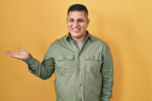 Hispanic Young Man Standing Yellow Background Smiling Cheerful Presenting Pointing — Stock Photo, Image