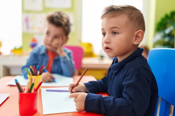 stock image Adorable boys preschool students sitting on table drawing on paper at kindergarten