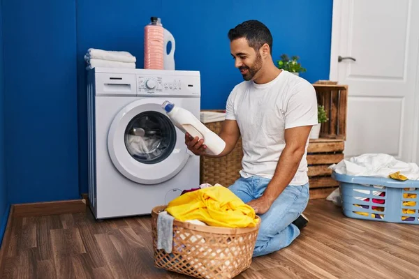 Young Hispanic Man Washing Clothes Holding Detergent Bottle Laundry Room — Stock Photo, Image