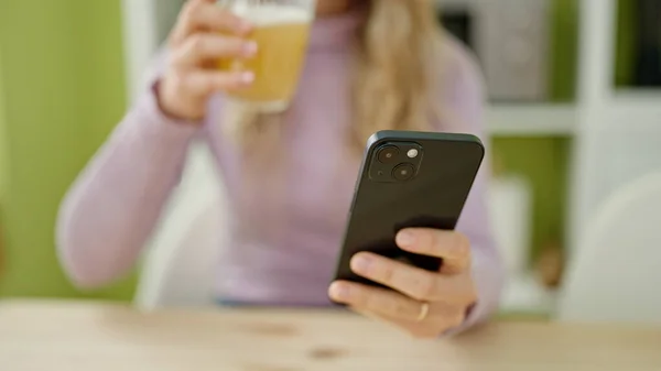 Jonge Blonde Vrouw Met Glas Sinaasappelsap Met Smartphone Eetkamer — Stockfoto