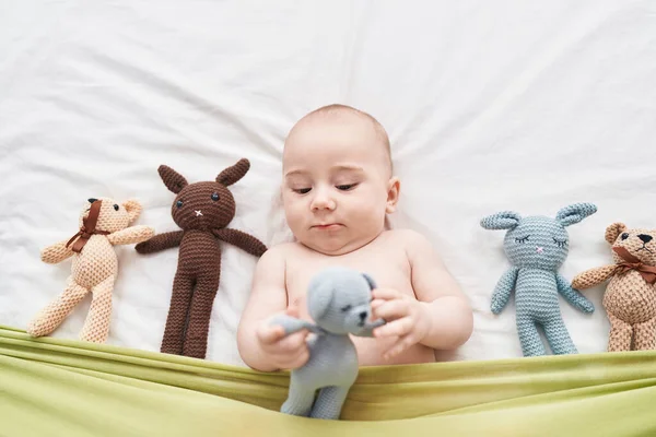 Sevimli Beyaz Bebek Yatak Odasında Bebeklerle Yatakta Yatıyor — Stok fotoğraf