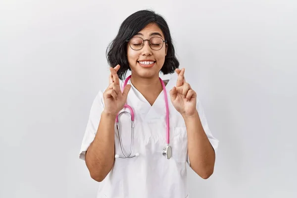 Młoda Latynoska Lekarka Nosząca Stetoskop Odosobnionym Tle Gestykulująca Palec Skrzyżowany — Zdjęcie stockowe
