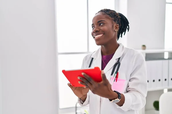 アフリカ系アメリカ人女性医師の制服を着てクリニックでタッチパッドを使用 — ストック写真