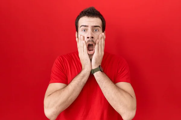 Jovem Hispânico Homem Vestindo Casual Vermelho Shirt Medo Chocado Surpresa — Fotografia de Stock
