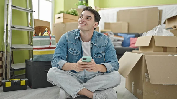 Genç Spanyol Adam Akıllı Telefon Kullanıyor Yeni Evinde Yerde Oturuyor — Stok fotoğraf