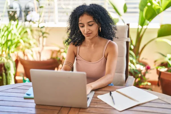 stock image Young hispanic woman using laptop sitting on table at home terrace