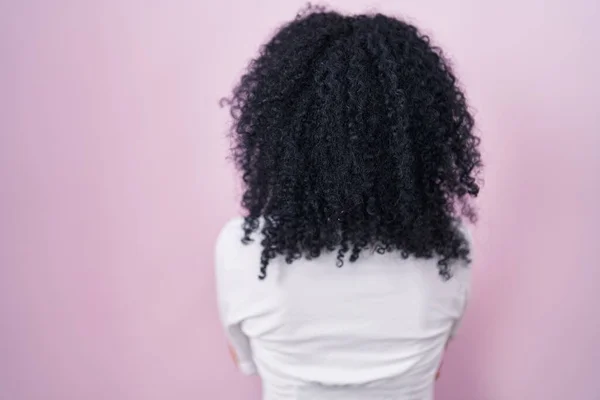 Pembe Arka Planda Duran Kıvırcık Saçlı Spanyol Kadın Kollarını Kavuşturup — Stok fotoğraf