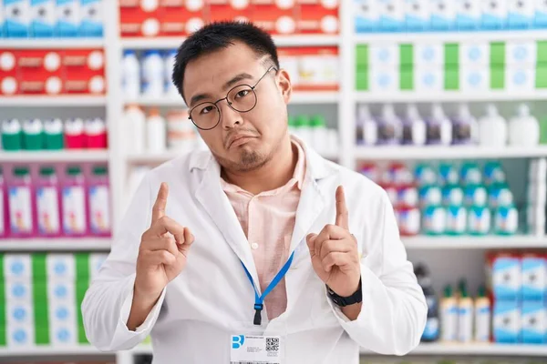 Китайский Молодой Человек Работающий Аптеке Указывает Печальный Расстроенный Вид Указывая — стоковое фото