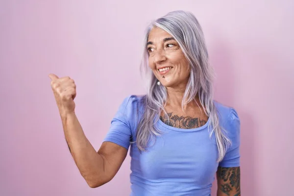 Medelålders Kvinna Med Tatueringar Står Över Rosa Bakgrund Ler Med — Stockfoto