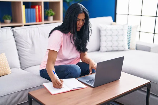 Middle Age Hispanic Woman Using Laptop Writing Notebook Home — Stock Photo, Image