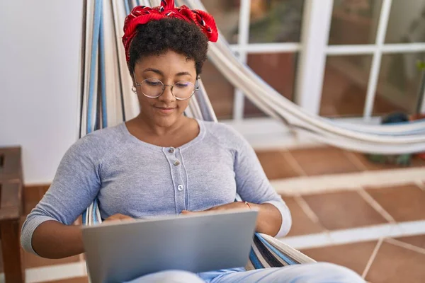 African American Woman Using Laptop Lying Hammock Home Terrace —  Fotos de Stock