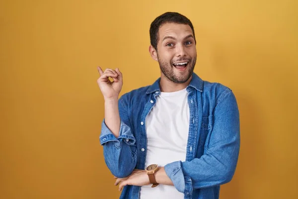 Hispanic Man Standing Yellow Background Big Smile Face Pointing Hand — Stockfoto