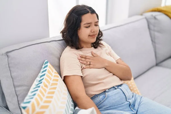 Junge Frau Sitzt Auf Sofa Und Berührt Brust Hause — Stockfoto