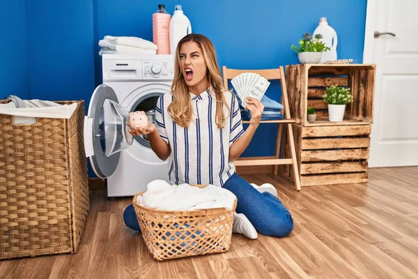 Mujer Rubia Joven Haciendo Lavandería Ahorrando Dinero Enojado Loco Gritando —  Fotos de Stock