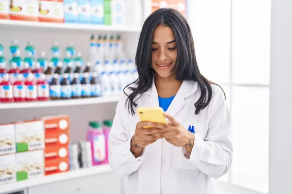 Young Hispanic Woman Pharmacist Using Smartphone Working Pharmacy — 스톡 사진