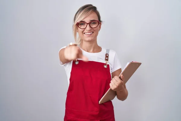 Young Blonde Woman Wearing Waiter Uniform Holding Clipboard Pointing You — Stock Photo, Image