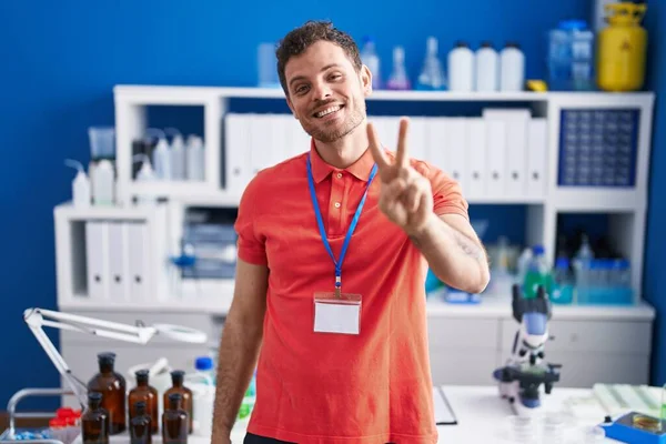 Young Hispanic Man Working Scientist Laboratory Smiling Looking Camera Showing — Stock Photo, Image