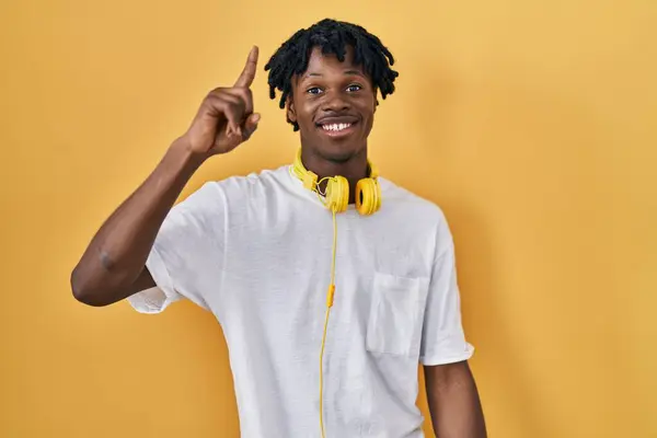 Joven Hombre Africano Con Rastas Pie Sobre Fondo Amarillo Apuntando — Foto de Stock