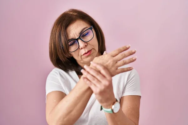 ピンクの背景の上に立つ中世のパニック女性手や指に痛み 関節炎の炎症 — ストック写真