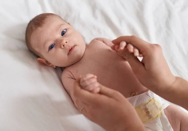 Sevimli Beyaz Bebek Yatak Odasında Annesinin Elini Tutarak Uzanıyor — Stok fotoğraf