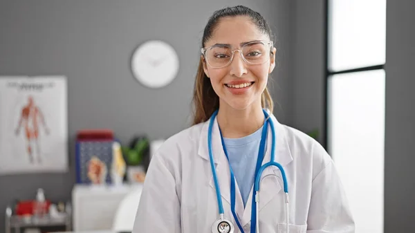 Νεαρή Όμορφη Ισπανίδα Γιατρός Χαμογελά Σίγουρος Στέκεται Στην Κλινική — Φωτογραφία Αρχείου