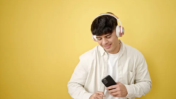 Ung Latinamerikansk Man Lyssnar Musik Dans Över Isolerad Gul Bakgrund — Stockfoto