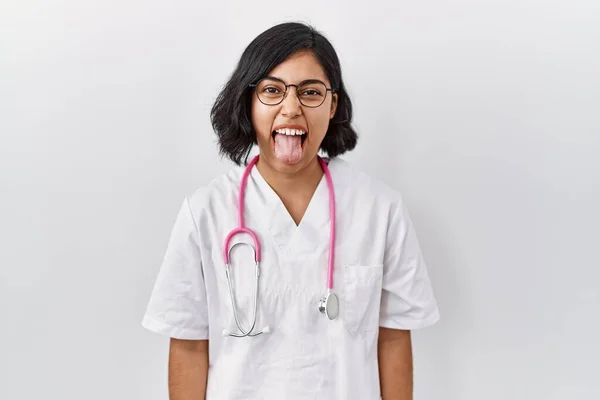 Mladá Hispánská Doktorka Oblečená Stetoskopu Izolovaném Pozadí Vystrkující Jazyk Spokojená — Stock fotografie