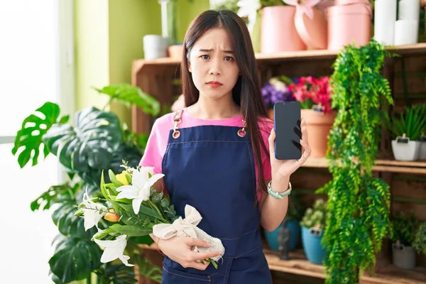 Jovem Chinesa Trabalhando Florista Loja Mostrando Tela Smartphone Cético Nervoso — Fotografia de Stock