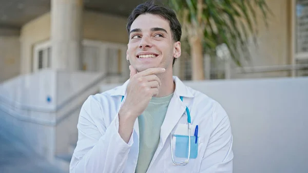Joven Médico Hispano Sonriendo Confiado Pensando Hospital —  Fotos de Stock
