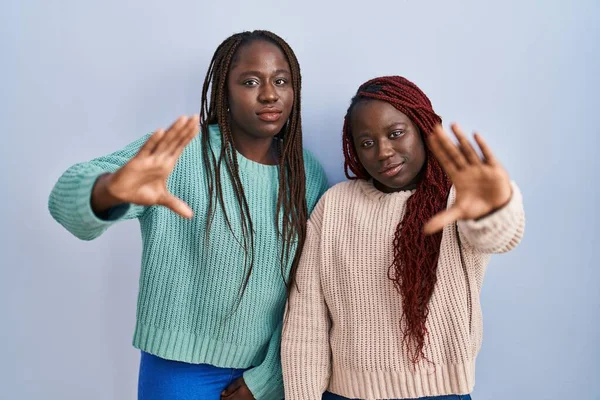 Две Африканки Стоящие Синем Фоне Делают Рамку Ладонями Пальцами Смотрят — стоковое фото