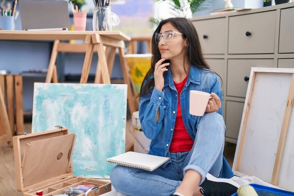 年轻的惊慌失措的女艺人带着自信的笑容在艺术工作室喝咖啡 — 图库照片