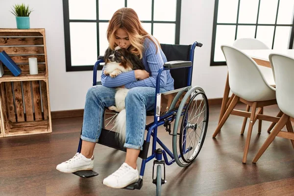 Tekerlekli Sandalyede Oturan Beyaz Bir Kadın Evde Sarılıp Köpeğini Öpüyor — Stok fotoğraf