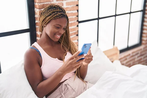 Mujer Afroamericana Usando Teléfono Inteligente Sentado Cama Dormitorio —  Fotos de Stock