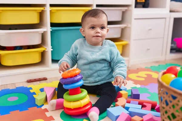 愛らしいヒスパニック赤ちゃん遊びとともにフープゲーム座っています床に幼稚園 — ストック写真