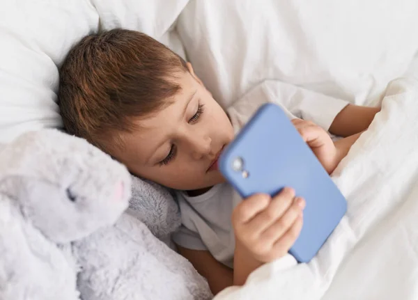Чарівний Білий Хлопчик Допомогою Смартфона Лежить Ліжку Лялькою Спальні — стокове фото