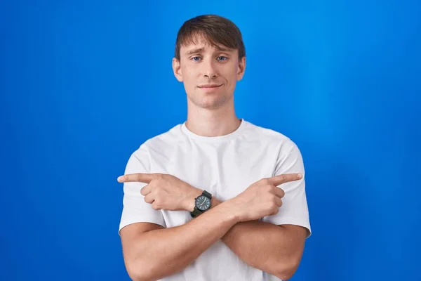 Caucasian Blond Man Standing Blue Background Pointing Both Sides Fingers — Stock Photo, Image