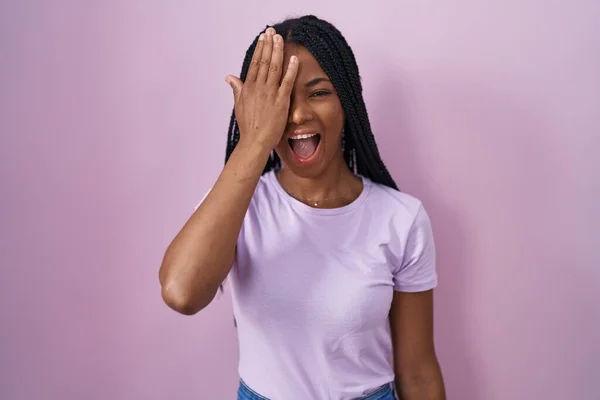 Африканская Американка Косичками Стоящими Розовом Фоне Закрывая Один Глаз Рукой — стоковое фото