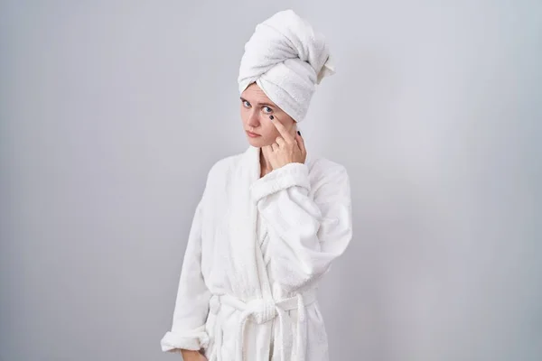 Blonde Caucasian Woman Wearing Bathrobe Pointing Eye Watching You Gesture — Stock Photo, Image
