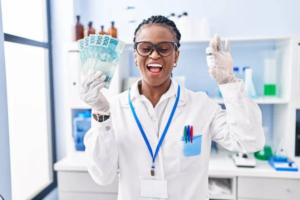 笑顔で大声で笑うお金を保持し 科学研究所で働いているアフリカの女性のため面白いクレイジー冗談 — ストック写真
