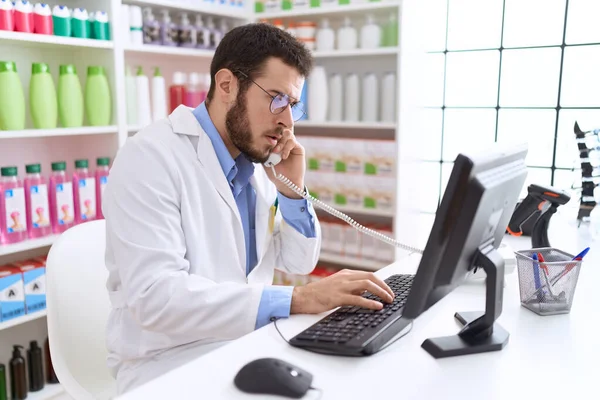 Jovem Homem Hispânico Farmacêutico Falando Por Telefone Usando Computador Farmácia — Fotografia de Stock