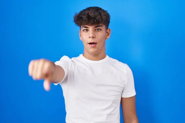 Ισπανόφωνος Έφηβος Στέκεται Πάνω Από Μπλε Φόντο Δείχνοντας Δάχτυλο Έκπληκτος — Φωτογραφία Αρχείου
