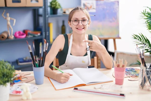 young blonde woman drawing in at art studio