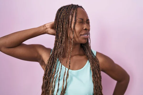 非洲裔美国妇女站在粉红的背景上 颈部疼痛 手摸脖子 肌肉疼痛 — 图库照片