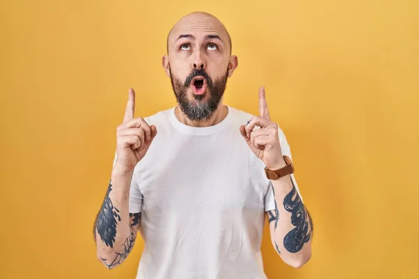 Young Hispanic Man Tattoos Standing Yellow Background Amazed Surprised Looking — Stock Photo, Image