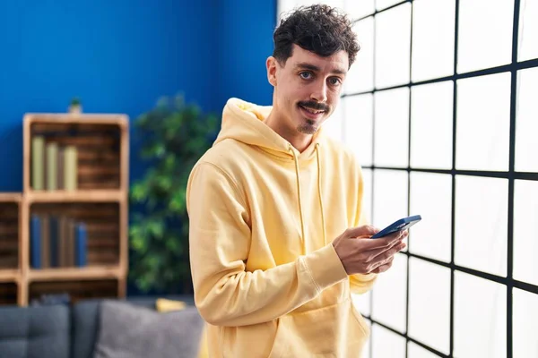 Young Caucasian Man Using Smartphone Standing Home — Stockfoto