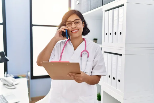 Mladá Latinská Žena Uniformě Lékaře Mluví Smartphonu Klinice — Stock fotografie
