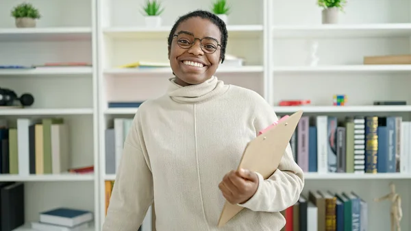 Africano Americano Mulher Estudante Sorrindo Confiante Segurando Prancheta Biblioteca Universidade — Fotografia de Stock