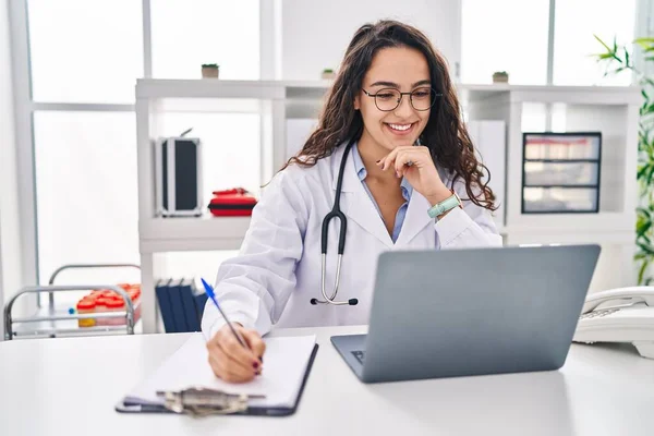 Young Hispanic Woman Wearing Doctor Uniform Using Laptop Working Clinic — Stockfoto